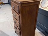 une grande commode en bois à cinq tiroirs dans une pièce