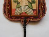 un vieux ventilateur orné d'une peinture représentant un homme tenant un journal