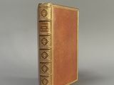 un vieux livre posé sur une table à côté d'un fond gris