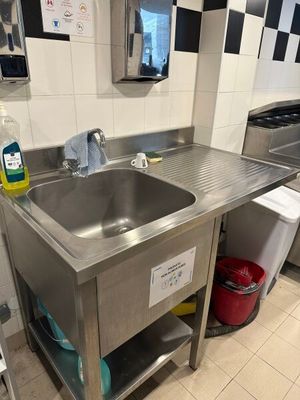 un évier de cuisine avec une poubelle et une poubelle