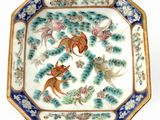 a decorative plate with fish and flowers on it