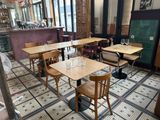 des tables et des chaises dans un restaurant, avec un ventilateur en arrière-plan