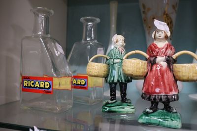 trois figurines représentant des femmes tenant des paniers, posées sur une étagère