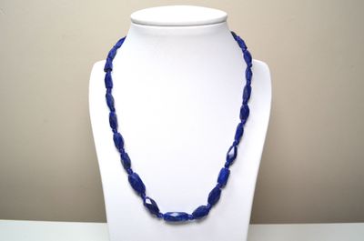 collier composé de perles de verre bleues sur un mannequin blanc