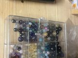 a box of marbles sitting on a desk next to a keyboard