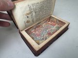 a person holding a book open on a table