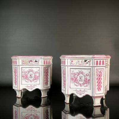 two pink and white vases sitting on a black table