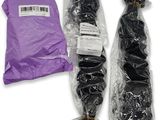 two bundles of black hair wrapped in plastic bags on a white surface