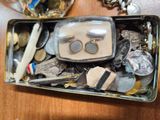 a metal container filled with assorted items on a wooden table