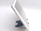 a white tablet computer sitting on a stand on a table