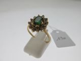 Gros plan sur une bague ornée d'une pierre verte