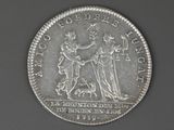 a close up of a silver coin with a man and woman on it