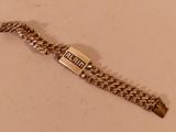 une photo d'un bracelet en argent sur lequel est accrochée une étiquette avec un nom
