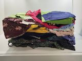 une pile de vêtements posée sur une étagère blanche
