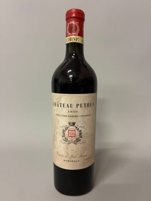 une vieille bouteille de vin posée sur une table blanche