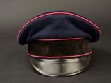 blue hat with red pips on top of a metal stand