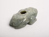 a picture of a green frog figurine on a white surface
