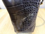 a black purse that is sitting on a wooden table