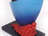 a sculpture of a blue bowl with red tomatoes on it
