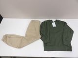 a green sweater and khaki pants on a white table