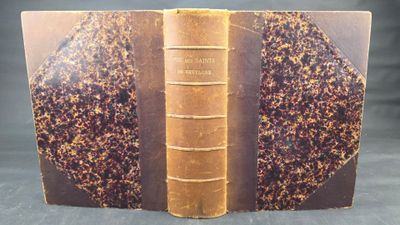 an old book with a brown cover sitting on top of a table