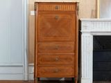 a tall chest of drawers next to a fireplace in a living room