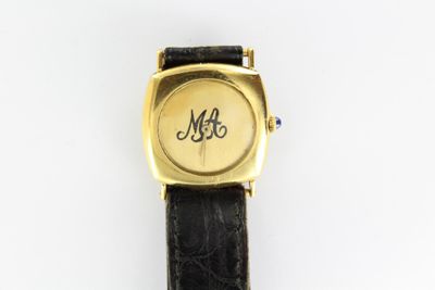 un gros plan d'une montre-bracelet portant un monogramme