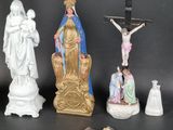 four figurines of jesus and a crucifix on a table