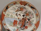 three decorative plates with asian designs on them sitting on a table