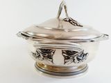 an antique silverplated bowl with a lid on a white surface