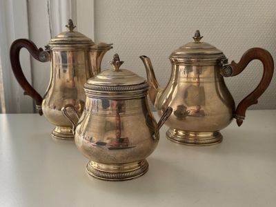 three silver teapots sitting on a table next to each other