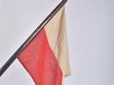 a red and white flag on a pole on a white background