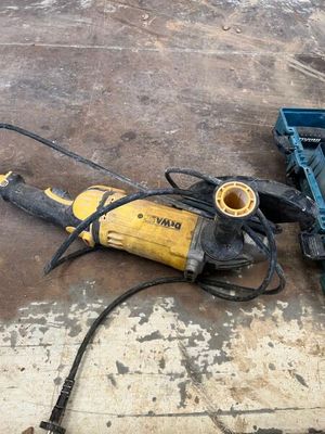 a picture of a drill and other tools on a concrete floor