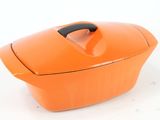 an orange casserole dish with a handle on a white surface