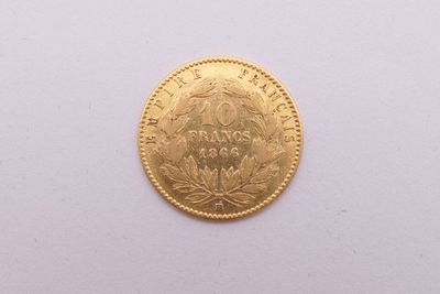 gros plan d'une pièce d'or sur une surface blanche
