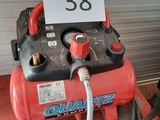 a red air compressor sitting on top of a pallet