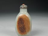 a small glass bottle with a brown and white design on it