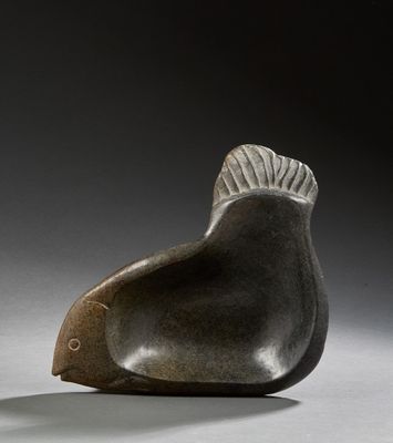 sculpture of a fish on a gray surface with a black background