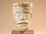 sculpture of a man ' s face on a wooden base