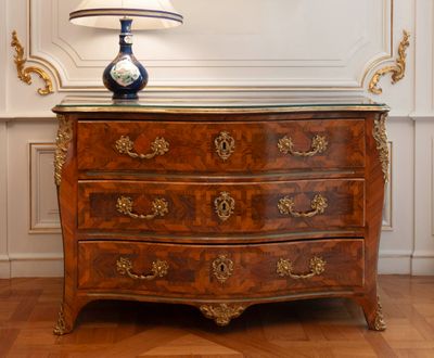 a dresser with a lamp on top of it in a room