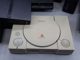 a video game system sitting on a table next to a laptop