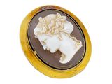 a close up of a gold plated broochle with a woman ' s face