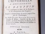 an open book on a white surface with black writing on it