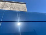 the sun shines brightly on the roof of a blue building