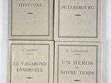 quatre livres sont empilés sur une surface blanche