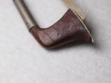 a small wooden stick with a wooden handle on a white surface