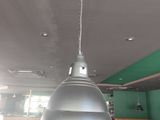 un grand luminaire métallique suspendu au plafond d'un restaurant