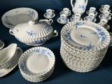 many pieces of blue and white china on a table