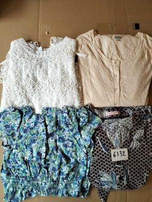 trois hauts et shorts pour femmes disposés sur une boîte en carton