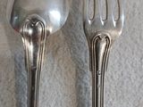 deux cuillères et une fourchette en argent sur une table